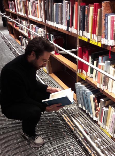 Axel Moulinier devant les rayonnages dédiés aux collectionneurs, libre accès de la bibliothèque de l'INHA. Cliché INHA