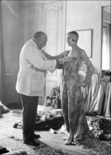 Thérèse Bonney, Paul Poiret photographié avec le mannequin Renée dans les salons de sa maison de couture, 1927, photographie positive par l'ARCP d'après le négatif. © The Bancroft Library, University of California, Berkeley / Thérèse Bonney / BHVP, cote : NN-006-02706.